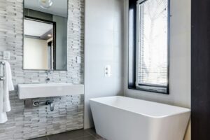 white ceramic bathtub near white framed window