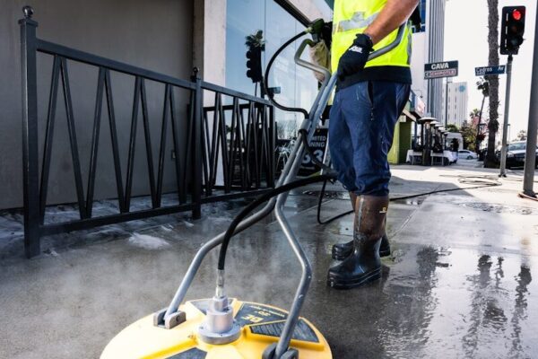 a man in a yellow vest is cleaning the street