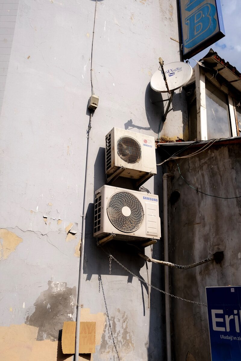 a group of white and black satellite dishes on a white building