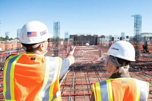 man in white hard hat standing on brown wooden dock during daytime